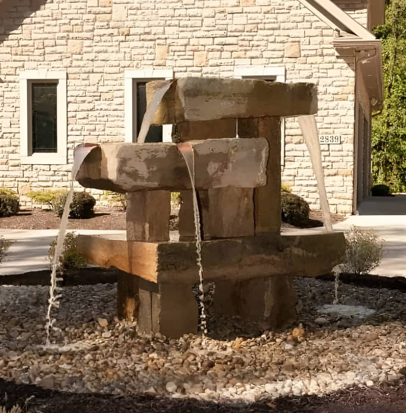 A beautiful fountain with three tiers that is circled by stone