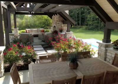 A covered dining area just steps from the outdoor fireplace accommodates 8-10 diners and overlooks the homeowner’s rose garden.
