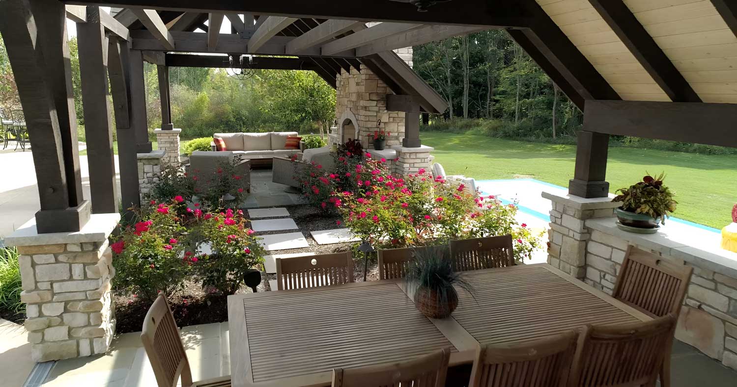 A covered dining area just steps from the outdoor fireplace accommodates 8-10 diners and overlooks the homeowner’s rose garden.
