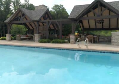 Two covered seating areas separated by stately wooden arches and a gorgeous rose garden offer relief from the sun.