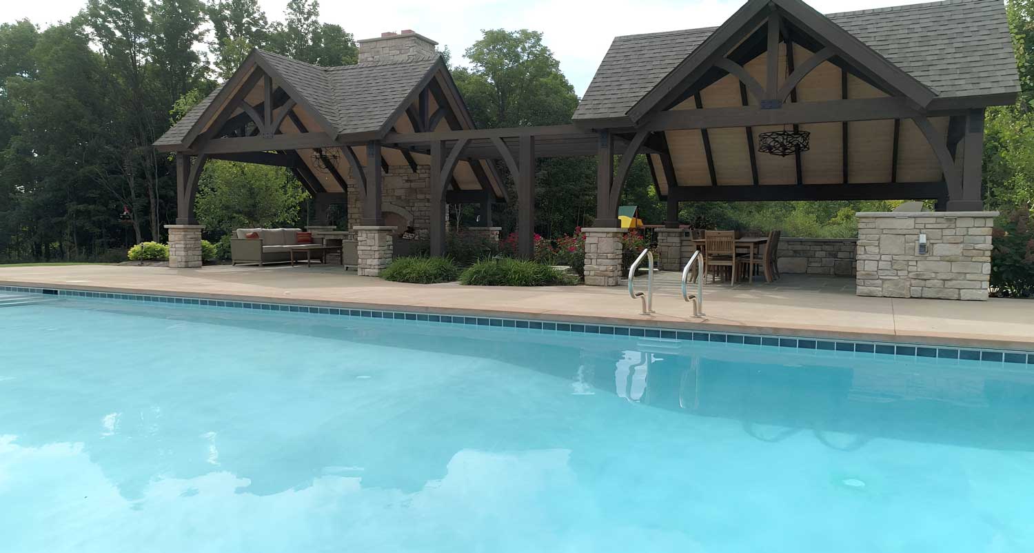 Two covered seating areas separated by stately wooden arches and a gorgeous rose garden offer relief from the sun.