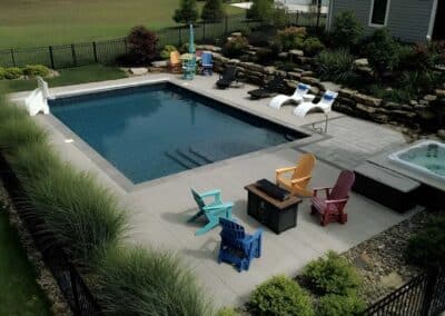 The homeowner chose colorful Adirondack seating to add a playful vibe to the outdoor entertainment spaces.