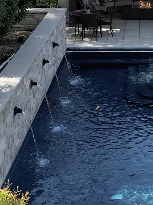 fountain-closeup overhead shot of a pool with a stone staircase leading into clear blue water
