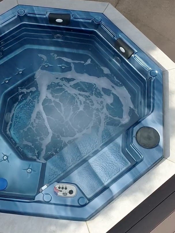 hottub-close aerial view of an outdoor living space with landscaping and stone features