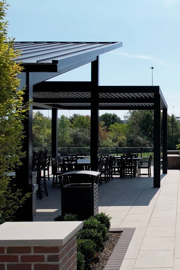 overhead-structure two black metal overhead structures with plenty of seating on a stone patio