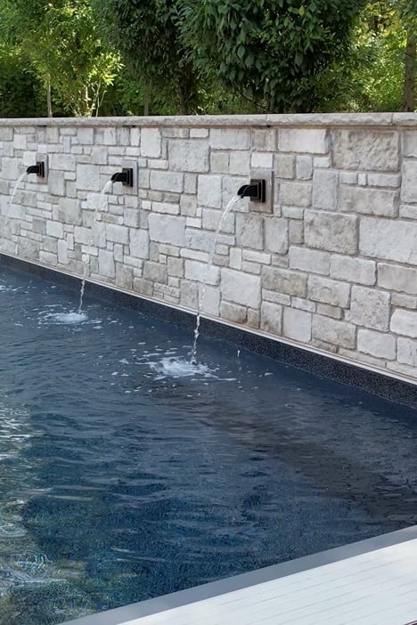 three-fountains three fountains pour water out of a stone wall into a pool below