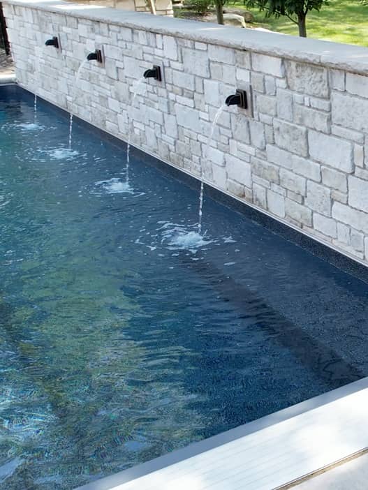 Waterfall-feature overhead shot of a pool with a diving board